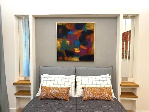a bedroom with a bed with a painting on the wall at ERASMO 19 Luxury Home in Catania