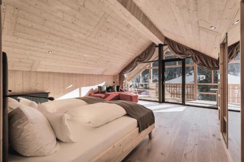 um quarto com uma cama grande num quarto com janelas em Tenne Lodges em Racines