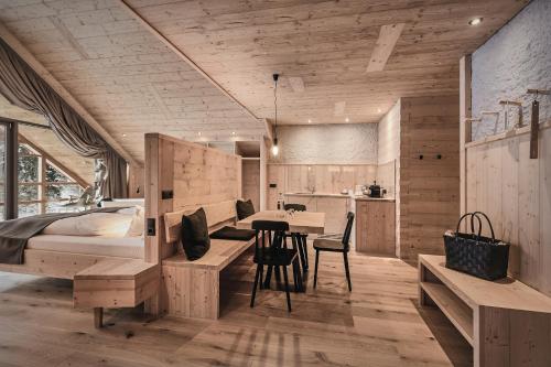 a bedroom with a bed and a table and chairs at Tenne Lodges in Racines