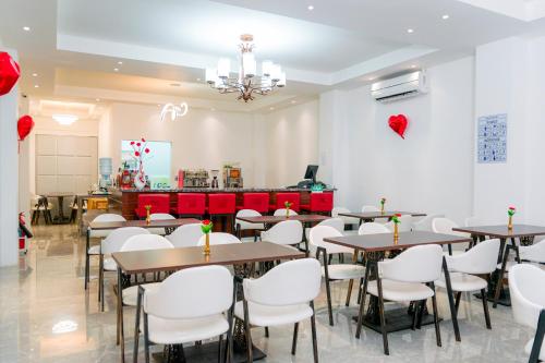 L'ver Hotel في Somoto: غرفة طعام مع طاولات وكراسي بيضاء