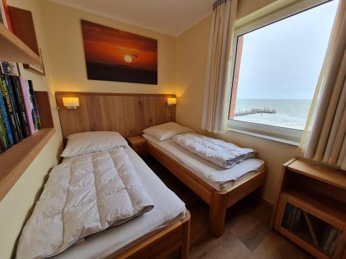 Duas camas num pequeno quarto com uma janela em Seeblick em Wyk auf Föhr
