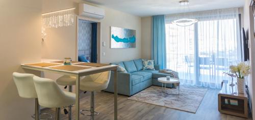 a living room with a blue couch and a table at Coral Luxury Apartment in Siófok
