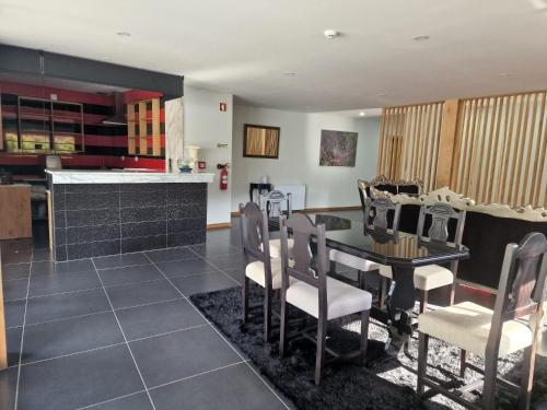 a kitchen and dining room with a table and chairs at Leonchic - Guest House com Piscina de Água Salgada in Barcelos