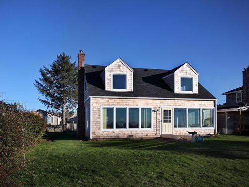 a brick house with a black roof and windows at Estuary Cottage in Seaside