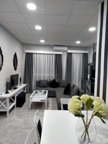 a living room with a couch and a table with flowers at María y Juan Apartamento con Garaje in Sanlúcar de Barrameda
