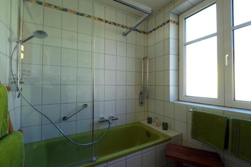 a bathroom with a green tub and a window at Ferienappartement Regina in Schrems