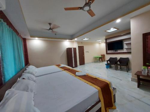 a bedroom with a large bed and a living room at ICONIC Hotel Digha in Digha