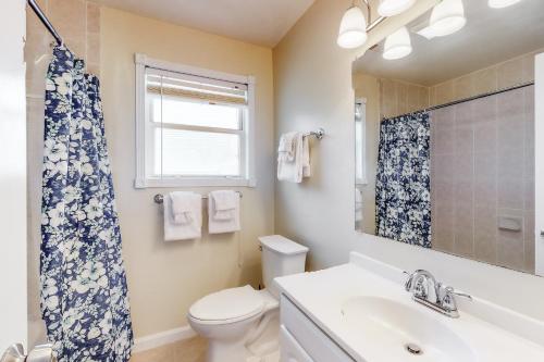 a bathroom with a toilet and a sink and a window at Drawbridge Rd 38 in Ocean Pines