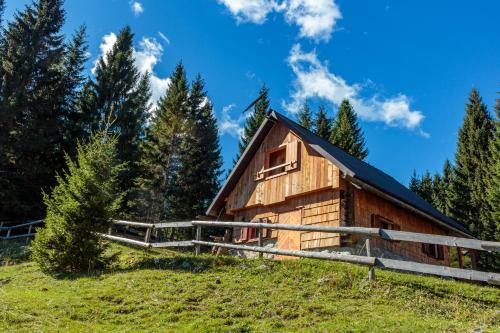 Cabaña de madera en una colina con árboles en Holiday house Pokljuka - Bohinj, en Koprivnik v Bohinju