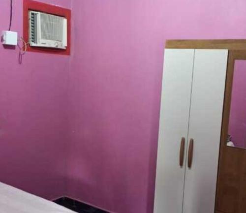 a bedroom with purple walls and a white cabinet at Casa Cantinho de Santarém in Santarém