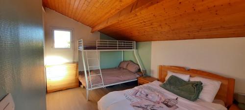 une chambre avec un lit superposé avec une échelle dans l'établissement Maison de village 4 à 6 pers à 5 min de la mer, à Bretignolles-sur-Mer