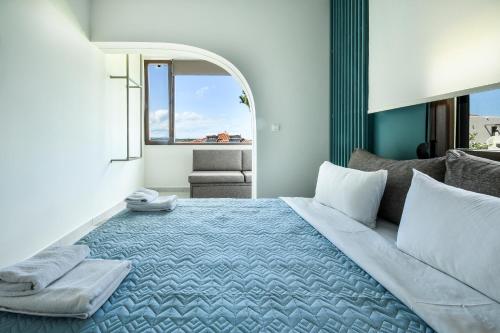 a bedroom with a large bed with a blue blanket at Zinozis Beach Apartments in Vourvourou