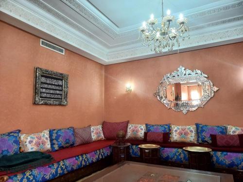a living room with a couch and a chandelier at SABOR VILLA TARGA GARDEN -Only Family in Marrakech