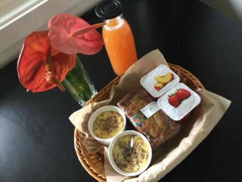 a table with a basket of food and a bottle of orange juice at Hale 'Ohu Bed & Breakfast in Volcano