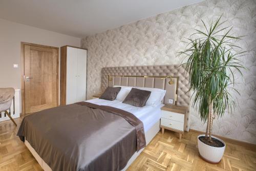 een slaapkamer met een bed en een potplant bij Apart-Wita in Wadowice