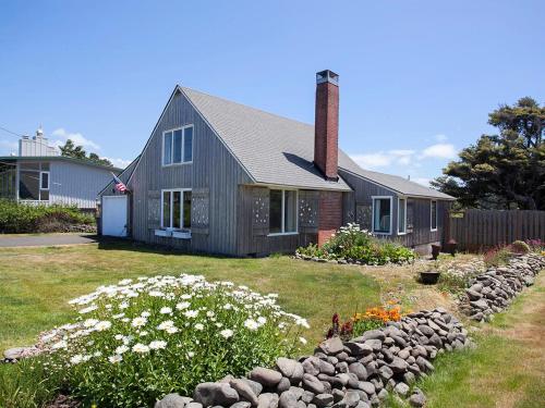 a house with a stone wall in front of it at Seaside Cove Vue in Seaside
