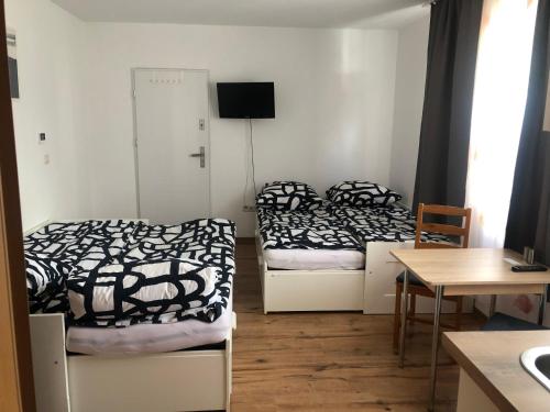 two beds in a room with a table and a desk at Vikrimp in Norderstedt
