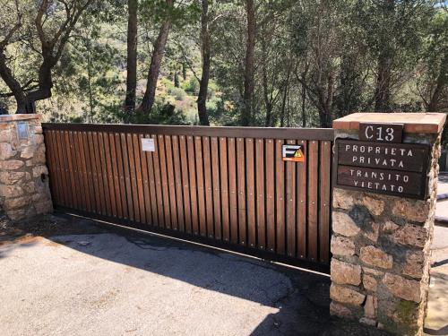 a wooden fence with a sign in front of it at Il Belvedere - Cannelle beach Argentario - Tuscany in Monte Argentario