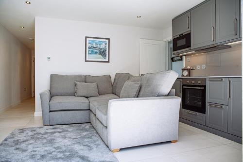 a living room with a couch and a kitchen at Sennen Cove Cottage in Sennen Cove