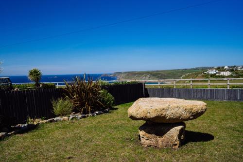a rock sitting on the grass in a yard at Sennen Cove Cottage in Sennen Cove