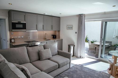 a living room with a couch and a kitchen at Sennen Cove Cottage in Sennen Cove