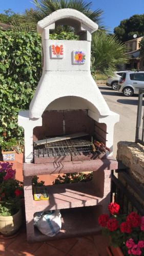 a stone oven with a flower garden in it at VILLA CORALLINA in San Vito lo Capo