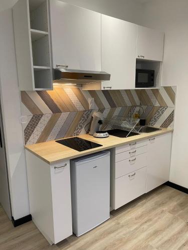 une cuisine avec des armoires blanches et un comptoir dans l'établissement Studio - Téléphérique/Gare, à Toulon