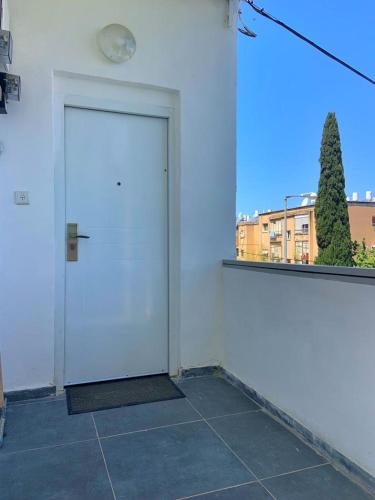 a white door in a room with a window at יחידות אירוח נוף המפרץ in Haifa