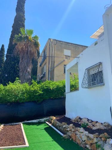 a white house with a yard with green grass at יחידות אירוח נוף המפרץ in Haifa