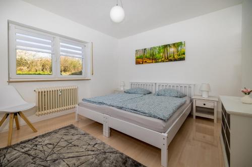 a bedroom with a bed and a desk and two windows at Ferienwohnung Melissa in Villingen-Schwenningen