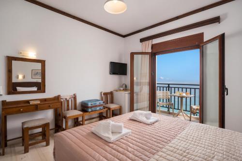 a bedroom with a bed and a view of the ocean at Lena Beach Hotel in Kalathas