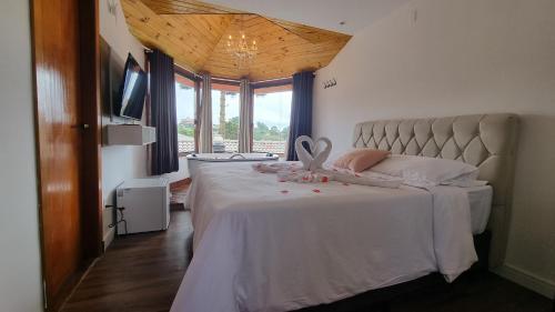 a bedroom with a bed with a white bedspread at Recanto dos Moinhos - Boutique Hotel in Campos do Jordão