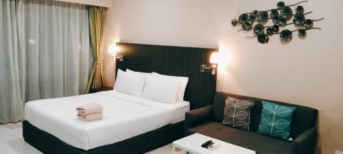 a hotel room with a bed and a chair at Mercu Summer Suites KLCC by Star Residence in Kuala Lumpur