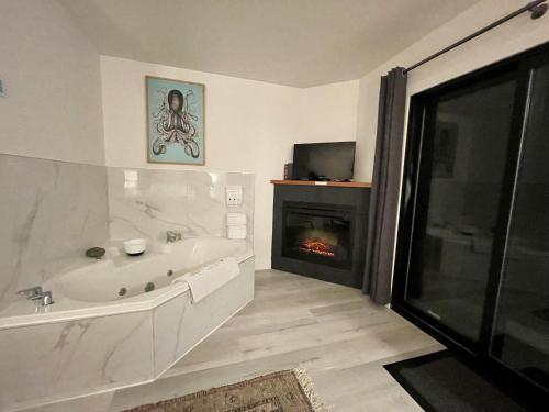 a bathroom with a bath tub and a fireplace at Private Oceanfront Room With Hot Tub & Firepit - Shore Thing in Ucluelet