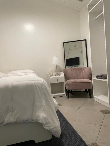 a bedroom with a bed and a chair and a mirror at Culver City Hostel in Los Angeles