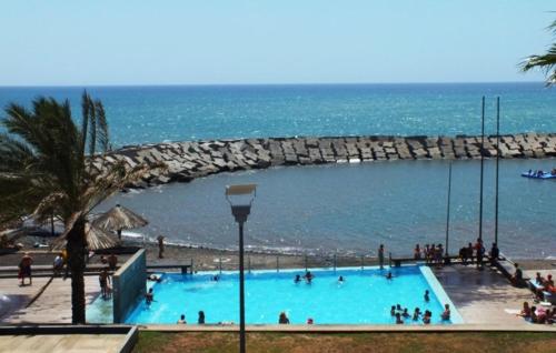 a large swimming pool with the ocean in the background at Lovely newly refurbished, 1 bedroom top floor apartment with sea views, fast WI-FI CABLE TV and Netflix in Ribeira Brava