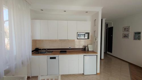 a kitchen with white cabinets and a sink at Apartament Amber in Sopot