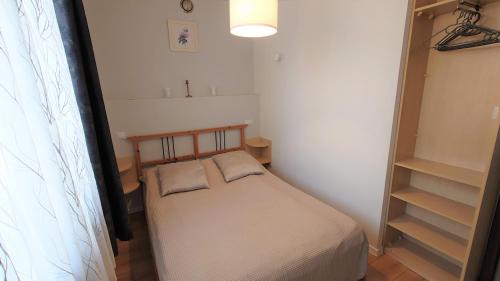 ein kleines Schlafzimmer mit einem Bett und einem Regal in der Unterkunft Apartament Amber in Sopot