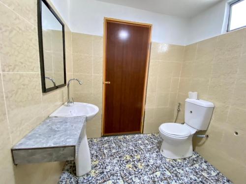 a bathroom with a toilet and a sink at JR RESORT in Ranau