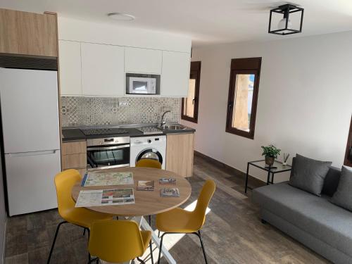 cocina y sala de estar con mesa y sofá en Apartamento Rural 2 Casa Bergua, en Arguis