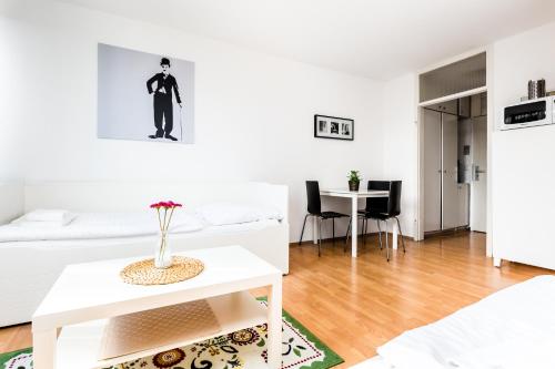 a white living room with a white bed and a table at Budget Apartment Köln in Cologne
