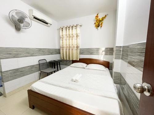 ein Schlafzimmer mit einem Bett und einem Stuhl darin in der Unterkunft Huy Hoàng Hotel in Ho-Chi-Minh-Stadt