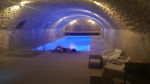 una donna stesa sul pavimento in una piscina di GITE DANINOU; meublé 3 chambres avec terrasse (1er étage du château) , salon et cuisine ouverte a Vouvray