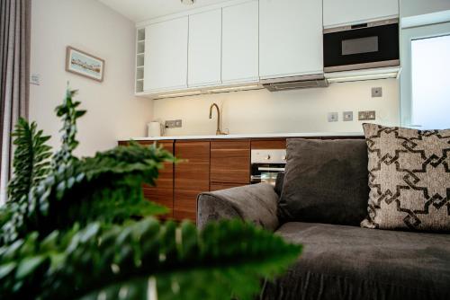 a living room with a couch and a kitchen at Sennen Cove Cottage in Sennen Cove