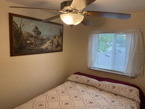 a bedroom with a bed with a ceiling fan and a window at Loft , boat dock, 2 bedrooms , pet friendly in Gravois Mills