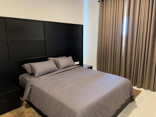 a bedroom with a large bed with a large headboard at Fairway 2 Bedroom Luxury Apartment with Gym and Pool in Battaramulla