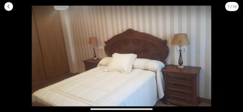 a bedroom with a large bed with a wooden headboard at OKTHEWAY MALPICA in Malpica