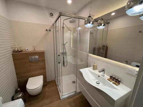 a bathroom with a shower and a sink and a toilet at Apartament BD Premium Klifowa in Rewal