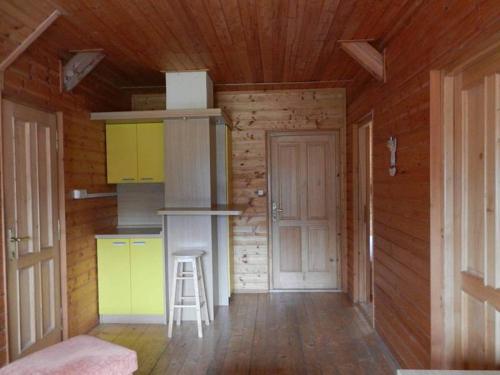 a kitchen with a stove and a stool in a room at Chata Orlice in Bartošovice v Orlických Horách