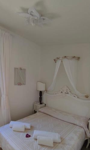 a white bedroom with a bed with two towels on it at Villa Sardinia Seaview&SPApool in Villasimius